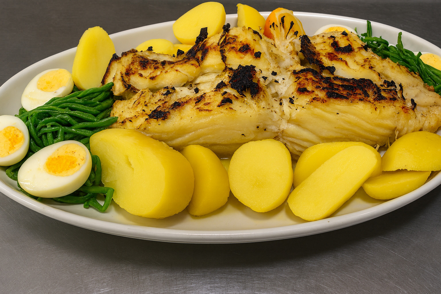 Bacalhau assado na brasa com batata cozida, feijão verde e ovo – prato português no Delfim Braga.